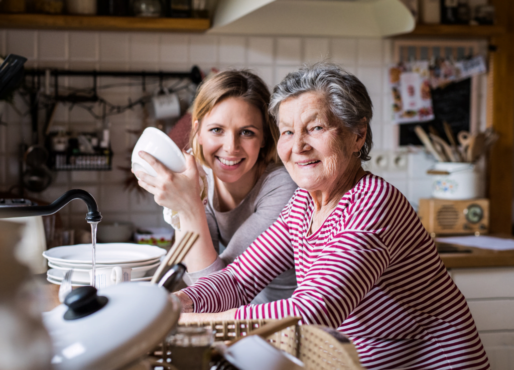 Daughter and elderly mother smiling in the kitchen