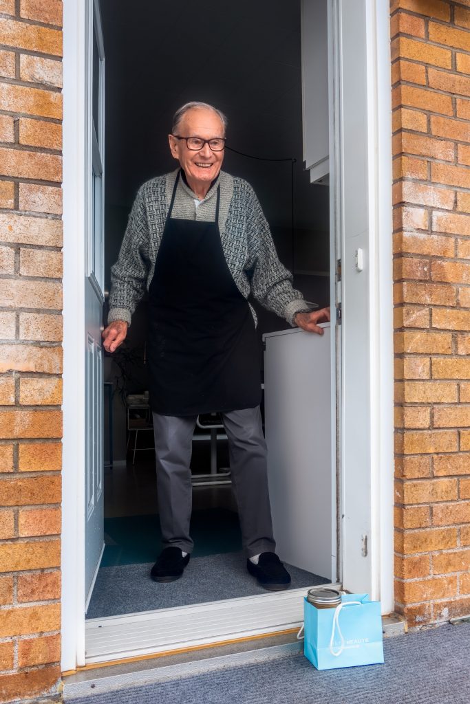 Elderly man standing at the font door